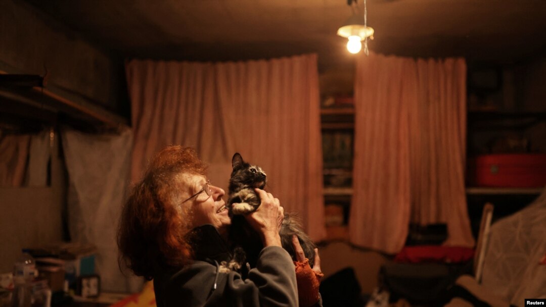 Natalia Pasternak (68) memegang salah satu kucing yang ditinggalkan oleh keluarga yang melarikan diri dari perang di lingkungannya di Saltivka utara, Kharkiv, Ukraina 18 Juli 2022. (REUTERS/Nacho Doce)