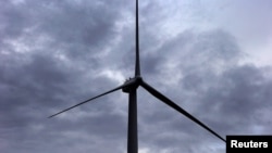 FILE - In this representative illustration, a worker stands atop a wind turbine during a routine inspection at the Infigen Energy wind farm located on the hills surrounding Lake George, 50 km north of the city of Canberra, Australia. Taken May 13, 2013.