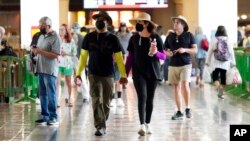 Travelers wear masks inside Union Station, July 28, 2022, in Los Angeles. Los Angeles County has dropped a plan to impose a universal indoor mask mandate as COVID-19 infections and rates of hospitalizations have stabilized.