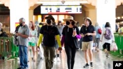 FILE - Several travelers wear masks inside Union Station, July 28, 2022, in Los Angeles. Ahead of a feared COVID-19 spike during the holiday season, the senior author of a study about COVID-19 called on people to wear masks to protect themselves.