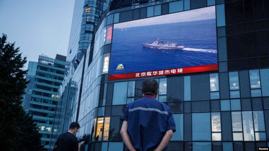 北京市民在观看街头电子屏幕上官媒央视播放的中国军队在台湾附近举行实弹军演的报道。（2022年8月4日）(photo:VOA)