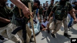 Indian policemen detain Kashmiri Shiite Muslims for participating in a religious procession during restrictions in Srinagar, Indian controlled Kashmir, Aug. 7, 2022.