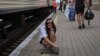 A young woman strokes a cat before a boarding a train to Dnipro and Lviv during an evacuation effort from war-affected areas of eastern Ukraine, amid Russia's invasion of the country, in Pokrovsk, Donetsk region, Ukraine, July 20, 2022. 
