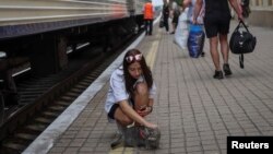 A young woman strokes a cat before a boarding a train to Dnipro and Lviv during an evacuation effort from war-affected areas of eastern Ukraine, amid Russia's invasion of the country, in Pokrovsk, Donetsk region, Ukraine, July 20, 2022. 