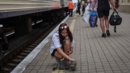 A young woman strokes a cat before a boarding a train to Dnipro and Lviv during an evacuation effort from war-affected areas of eastern Ukraine, amid Russia's invasion of the country, in Pokrovsk, Donetsk region, Ukraine, July 20, 2022. 