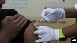 FILE - A man receives the AstraZeneca COVID-19 vaccine at Jabra Hospital in Khartoum, Sudan, March 11, 2021. A new philanthropic project hopes to invest $100 million in up to 10 countries mostly in Africa by 2030 to support up to 200,000 community health workers.