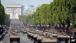 Vehículos militares registran la avenida de los Campos Elíseos durante el desfile por el Día de la Bastilla, el jueves 14 de julio de 2022 en París, Francia. (Foto AP/Christophe Ena)