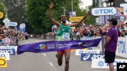 Tamirat Tola, of Ethiopia, celebrates as he crosses the finish line in the men's marathon at the World Athletics Championships in Eugene, Oregon, July 17, 2022. 