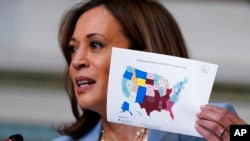 Vice President Kamala Harris holds up a map in the Indian Treaty Room on the White House complex in Washington, Aug. 3, 2022, during the first meeting of the interagency Task Force on Reproductive Healthcare Access.