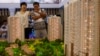 资料照：北京市民在房地产交易会上观看公寓楼模型。（2010年6月24日）
