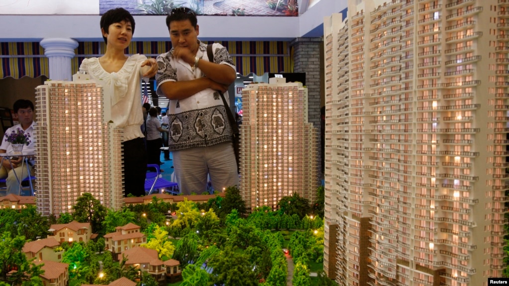 资料照：北京市民在房地产交易会上观看公寓楼模型。（2010年6月24日）(photo:VOA)