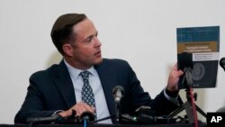 Texas House Investigation Committee Chairman Rep. Dustin Burrows holds up a copy of his full report on the Robb Elementary School shooting as the committee meets Sunday, July 17, 2022, in Uvalde, Texas. .  (AP Photo/Eric Gay)