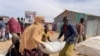 FILE - People carry bags of relief grains at a camp for the Internally Displaced People in Adadle district in the Somali region, Ethiopia, Jan. 22, 2022. Courtesy: Claire Nevill/World Food Program