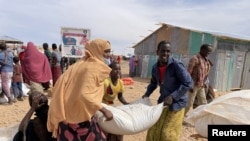 FILE - People carry bags of relief grains at a camp for the Internally Displaced People in Adadle district in the Somali region, Ethiopia, Jan. 22, 2022. Courtesy: Claire Nevill/World Food Program