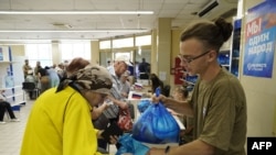 FILE - Residents receive food packages at an aid center administrated by the Russian ruling United Russia party in Melitopol in Zaporizhzhia region, on Aug. 2, 2022, amid the ongoing Russian military action in Ukraine.