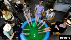 Residents at the Ter Biest house for elderly people dip their feet in a pool as a heat wave hits Europe, in Grimbergen, Belgium July 19, 2022.
