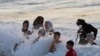 Sejumlah warga Palestina tampak bermain di pantai untuk mendinginkan badan mereka di tengah cuaca panas yang melanda pada 22 Juli 2022. Pantai tersebut terletak di Beit Lahia, sebelah utara Jalur Gaza. (Foto: AP/Hatem Moussa)