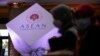 Two women wearing face mask walks in front of the ASEAN logo at a hotel where the 55th ASEAN Foreign Ministers' Meeting (55th AMM) is taking place in Phnom Penh, Cambodia, Tuesday, Aug. 2, 2022.