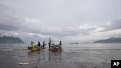 FILE - Local Cameroonian fishermen prepare fishing nets on their boats along the shores of Limbe beach, Cameroon, Apr. 12, 2022.