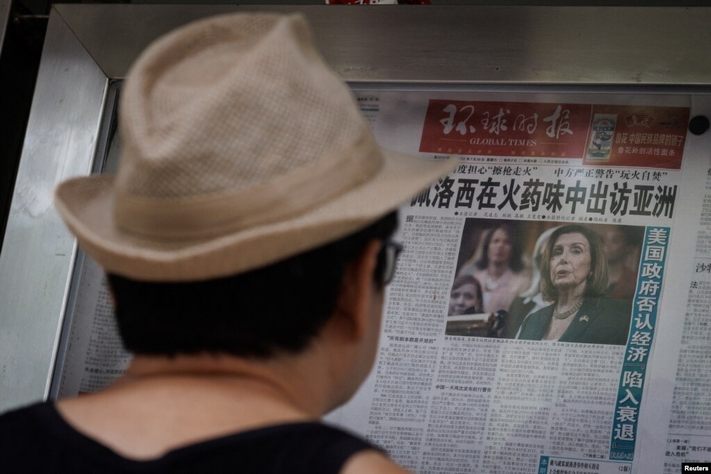 北京街头书报亭前一名男子在阅读环球时报报道佩洛西亚洲之行的文章。（2022年8月1日）(photo:VOA)