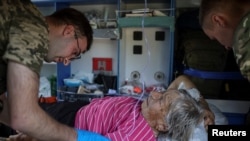 Ukrainian military paramedics attend resident Nina Trofimenko, 86, who was wounded during shelling near the frontline in the Donbas region of Ukraine amid Russia's attack on Ukraine, July 12, 2022.
