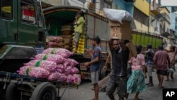 A porter carries a load of imported food items at a market place in Colombo, Sri Lanka, July 29, 2022.