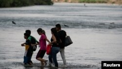 Asylum-seeking migrants cross the Rio Grande river from Mexico into the U.S., as seen from Piedras Negras, Mexico, July 13, 2022. 