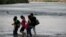 Asylum-seeking migrants cross the Rio Grande river from Mexico into the U.S., as seen from Piedras Negras, Mexico, July 13, 2022. 