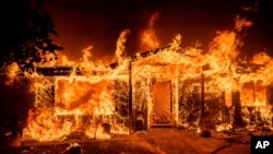 Flames consume a home on Triangle Rd. as the Oak Fire burns in Mariposa County, Calif., July 23, 2022. 