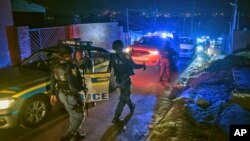 Police patrol an area in Soweto, South Africa, July 12, 2022, in search of illegal firearms following the weekend shooting in a bar which claimed the lives of 16 people.