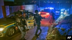 La police patrouille dans un quartier de Soweto, en Afrique du Sud, le 12 juillet 2022, à la recherche d'armes à feu illégales.