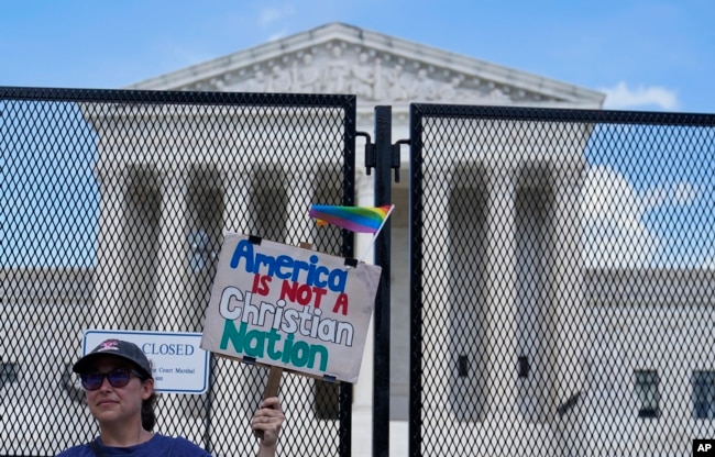 A demonstrator holds a sign in front of the U.S Supreme Court Monday, July 18, 2022, in Washington. (AP Photo/Mariam Zuhaib)