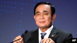 FILE - Thailand's Prime Minister Prayuth Chan-ocha adjusts microphones at a conference in Tokyo on May 26, 2022.