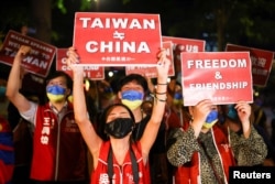 Demonstrators hold signs during a gathering in support of U.S. House of Representatives Speaker Nancy Pelosi's visit, in Taipei, Taiwan Aug. 2, 2022.