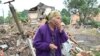 Seorang perempuan lansia warga setempat, Raisa Kuval (82 tahun), menangis saat menyaksikan sebuah bangunan yang hancur akibat tembakan artileri di kota Chuguiv, Kharkiv, Ukraina timur laut, 16 Juli 2022. (Foto: ilustrasi/ AFP) 