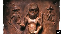 Ova fotografija muzeja Horniman prikazuje beninsku ploču od legure bakra koja predstavlja susret između beninskog poglavice Uwanguea i portugalskih trgovaca.