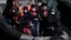 FILE - People thought to be migrants who undertook the crossing from France in small boats and were picked up in the Channel, arrive to be disembarked from a small transfer boat in Dover, south east England, June 17, 2022.