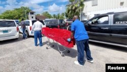 The body of a migrant from a vessel that capsized off the coast of The Bahamas is taken away by mortuary workers, in Nassau, Bahamas, July 24, 2022.