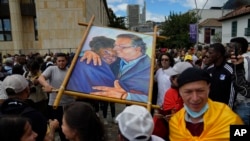 Partidarios del nuevo presidente Gustavo Petro exhiben una pintura de él con la nueva vicepresidenta Francia Márquez mientras esperan la ceremonia de juramentación en la plaza de Bolívar en Bogotá, Colombia, el domingo 7 de agosto de 2022. (Foto AP/Ariana Cubillos )