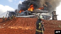 FILE - Syrian firefighters extinguish fire following artillery shelling by the Syrian regime on a fuel depot affiliated to the Hayat Tahrir al-Sham (HTS) jihadist group, Feb. 16, 2022 in the northwestern rebel-held town of Dana.