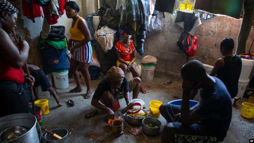 FILE - Seorang perempuan sedang memasak di penampungan keluarga yang mengungsi akibat kekerasan geng di Port-au-Prince, Haiti, 9 Desember 2021.