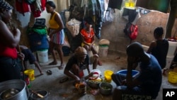 FILE - A woman prepares food at a shelter for families displaced by gang violence in Port-au-Prince, Haiti, Dec. 9, 2021.