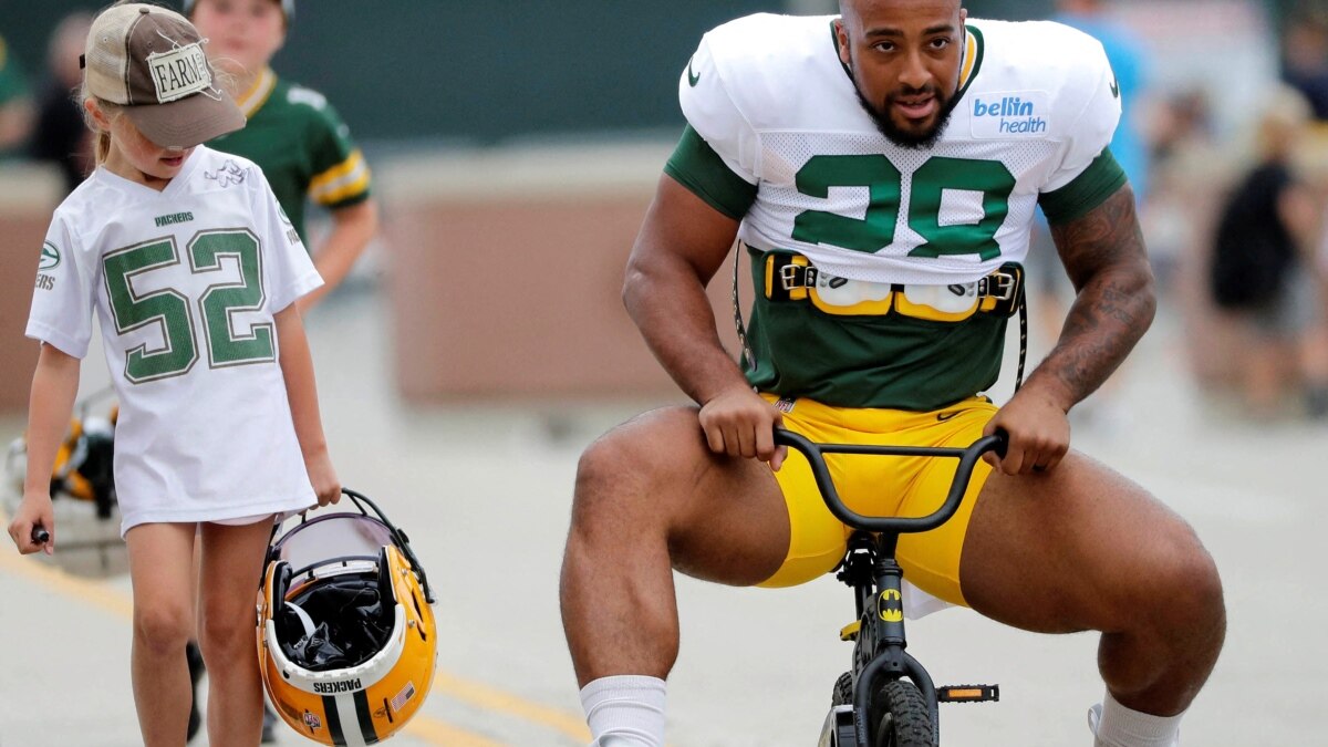 AJ Dillon of the Green Bay Packers rides a bike to training camp