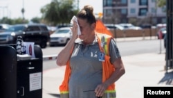 Vangie Jacobo wipes her face with a wet rag while working outside in 106° F heat in Phoenix, Arizona, July 23, 2022.