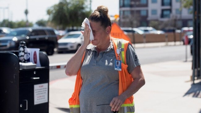 Vangie Jacobo wipes her face with a wet rag while working outside in 106° F heat in Phoenix, Arizona, July 23, 2022.