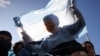 Un joven sostiene una bandera argentina mientras los trabajadores desempleados e informales marchan en protesta contra las políticas económicas del gobierno y en demanda de mejores condiciones de trabajo, en Buenos Aires, Argentina, 28 de julio de 2022. REUTERS/Cristina Sille