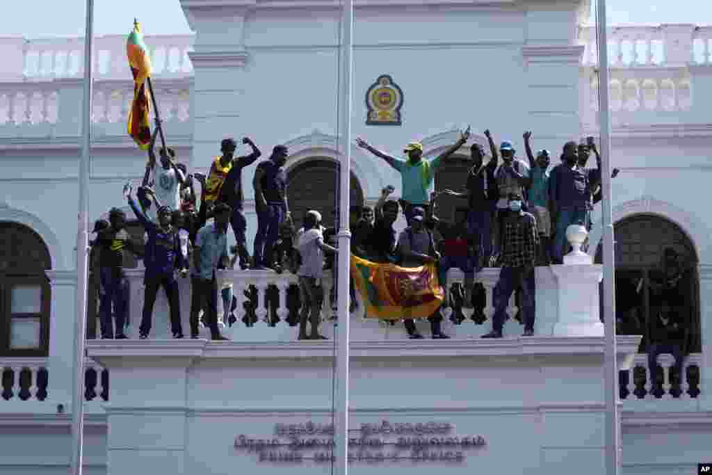 Protesters stand on top of Sri Lankan Prime Minister Ranil Wickremesinghe &#39;s office, demanding he resign after President Gotabaya Rajapaksa fled the country amid economic crisis in Colombo, July 13, 2022.