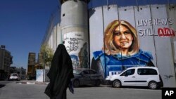 Mural buatan seniman Palestina Taqi Spateen yang berisi gambar jurnalis Palestina-Amerika Shireen Abu Akleh tersemat di tembok pemisah di Tepi Barat, Bethlehem, dalam foto yang diambil pada 6 Juli 2022. (Foto: AP/Mahmoud Illean)