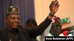 vote: FILE: Nigerias All Progressive Congress (APC) ruling party presidential candidate Bola Ahmed Tinubu (R) holds the arm of Kashim Shettima (L) during an APC meeting to unveil Shettima as its Vice-Presidential flagbearer in Abuja. Taken July 20, 2022. 