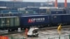A worker stands next to a train carrying China Railway Express containers at Chongqing railway port station, March 30, 2019.